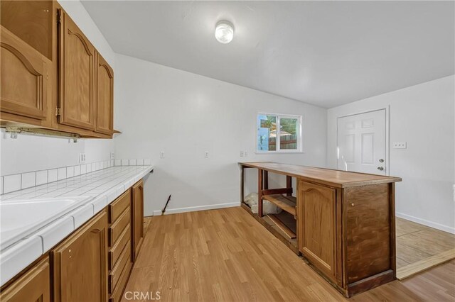 kitchen featuring vaulted ceiling and light wood-type flooring