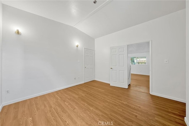 empty room featuring hardwood / wood-style flooring and vaulted ceiling