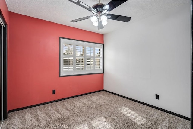 carpeted empty room featuring ceiling fan and a textured ceiling