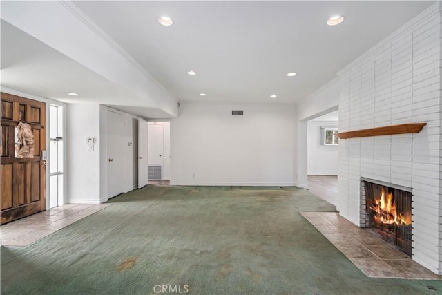 unfurnished living room featuring ornamental molding, carpet floors, and a brick fireplace