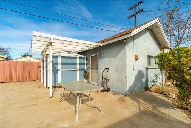 exterior space featuring a storage unit and a patio area