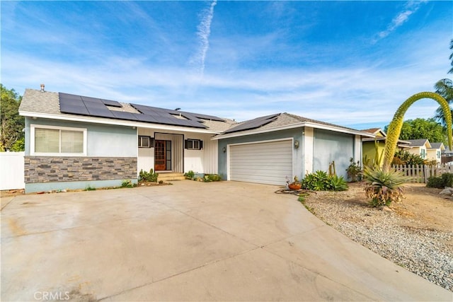 ranch-style house with a garage and solar panels