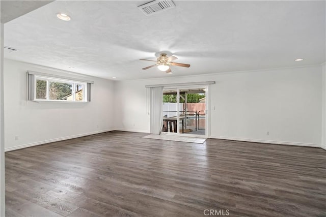 spare room with dark wood-type flooring, ornamental molding, and ceiling fan