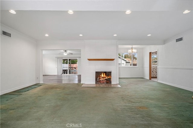 unfurnished living room with ornamental molding, carpet, ceiling fan with notable chandelier, and a fireplace