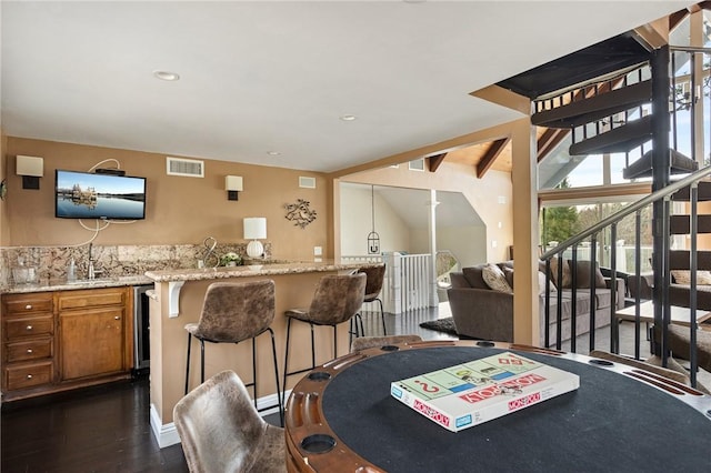 dining area featuring dark wood-type flooring, beverage cooler, and bar area