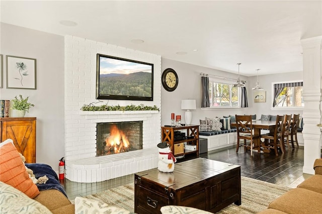 living room with a fireplace and decorative columns