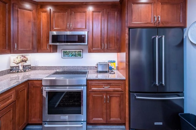 kitchen featuring stainless steel appliances and light stone counters