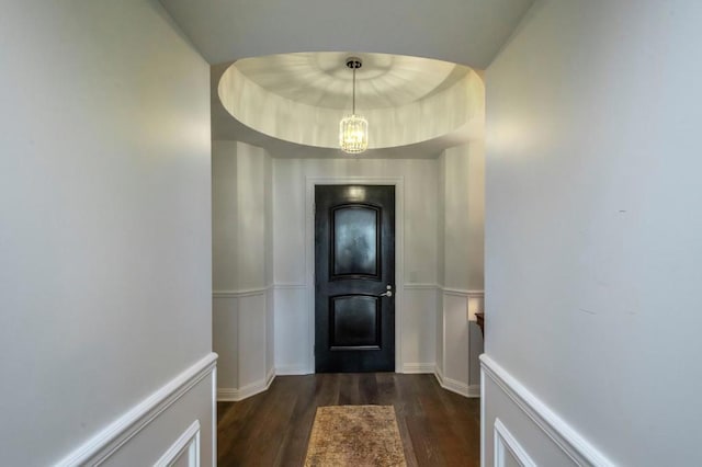 doorway with a notable chandelier and dark hardwood / wood-style flooring