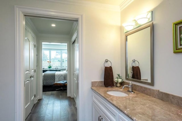 bathroom with vanity, hardwood / wood-style flooring, and ornamental molding