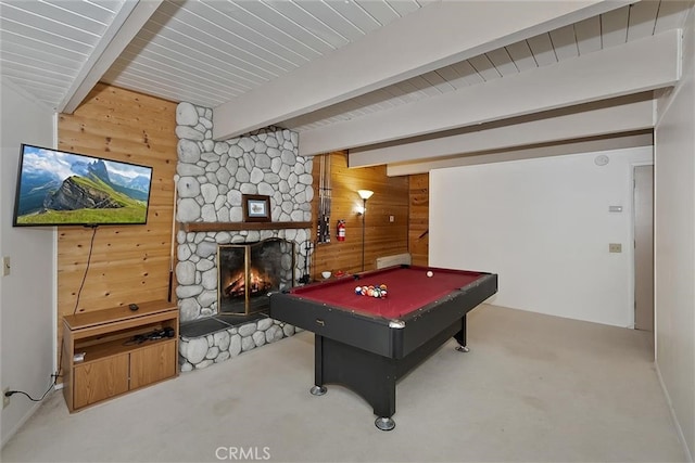 rec room featuring beamed ceiling, carpet floors, a fireplace, and wooden walls