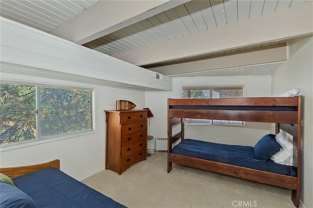 bedroom featuring beam ceiling, light carpet, and a baseboard heating unit