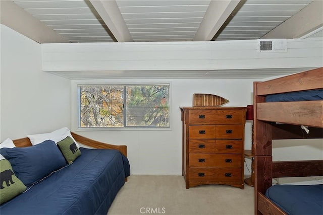 carpeted bedroom with beam ceiling