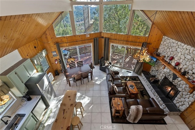 living room featuring light tile patterned flooring, a healthy amount of sunlight, and high vaulted ceiling