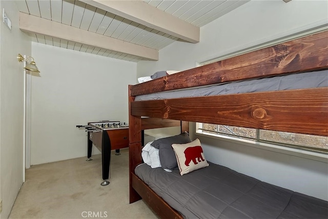 bedroom featuring light carpet and beamed ceiling