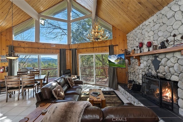 tiled living room with high vaulted ceiling, a wealth of natural light, a fireplace, and wood walls