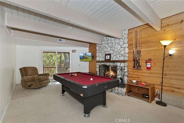 recreation room featuring billiards, beam ceiling, carpet floors, a stone fireplace, and wood walls