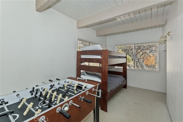 bedroom with beamed ceiling, light carpet, and wood ceiling