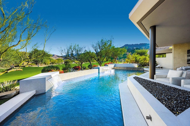 view of pool featuring pool water feature, a mountain view, and a patio area