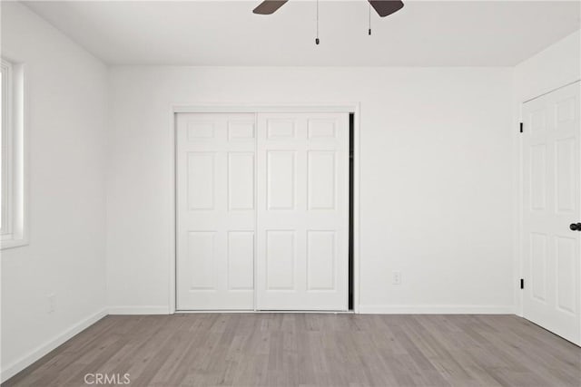 unfurnished bedroom with ceiling fan, a closet, and light hardwood / wood-style flooring