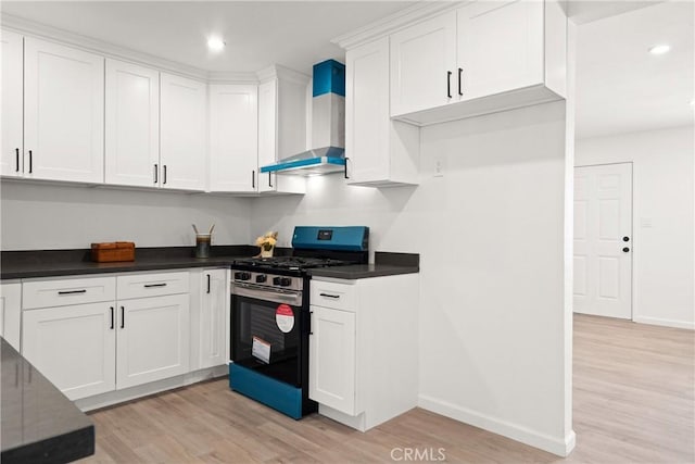 kitchen with white cabinetry, gas stove, light wood-type flooring, and wall chimney exhaust hood