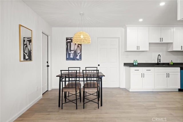 dining room featuring sink and light hardwood / wood-style floors