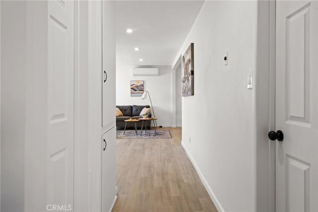 corridor featuring a wall mounted AC and light wood-type flooring