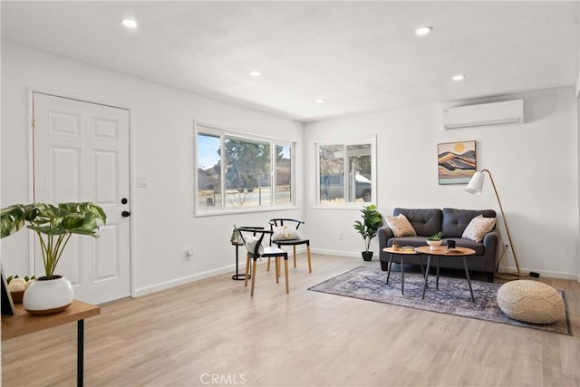 living area featuring light hardwood / wood-style floors and an AC wall unit