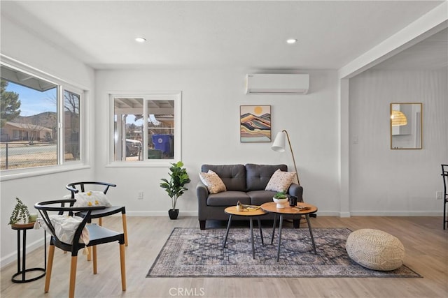 living room featuring a wall mounted air conditioner and light hardwood / wood-style floors