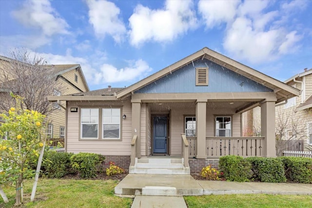 bungalow with a front yard and covered porch