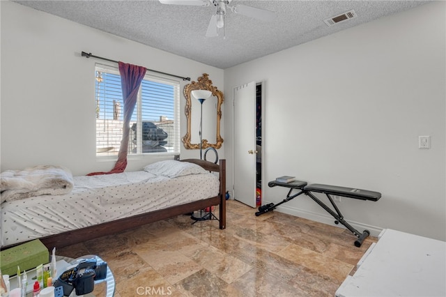 bedroom with a textured ceiling and ceiling fan