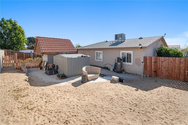 rear view of house with central AC, a storage shed, and a patio area