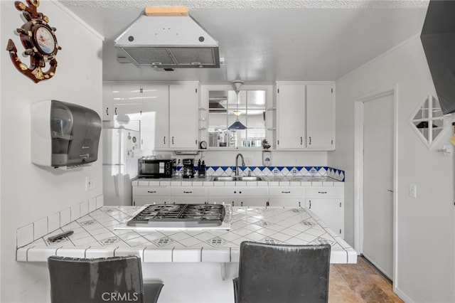 kitchen featuring white cabinetry, sink, tile countertops, and stainless steel gas stovetop