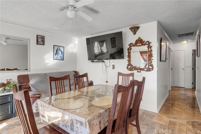 dining space with ornamental molding, a textured ceiling, and ceiling fan