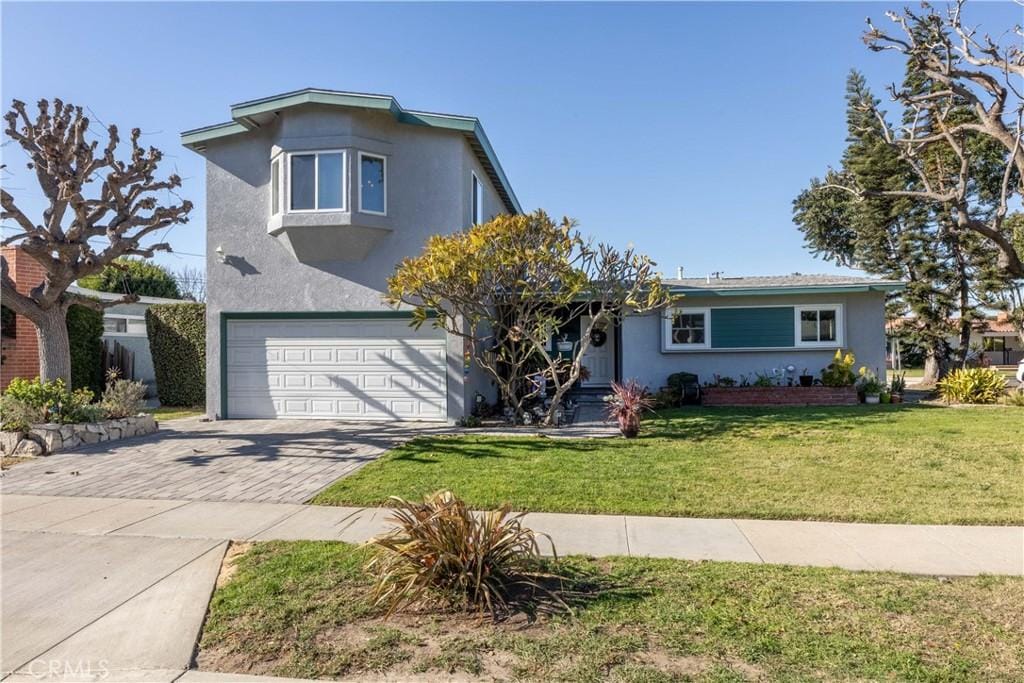 view of front property featuring a garage and a front lawn