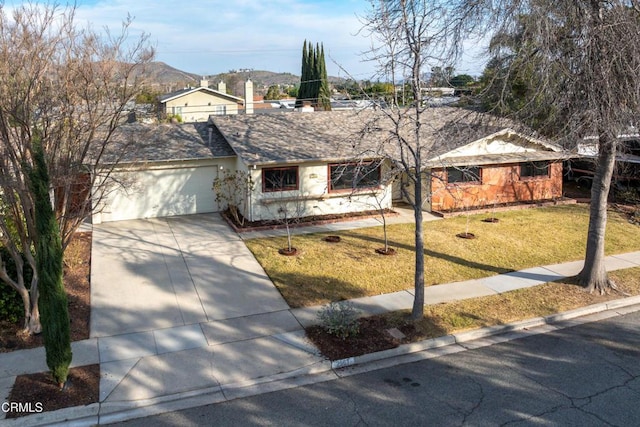 ranch-style house with a garage, a mountain view, and a front yard