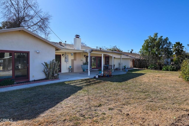 rear view of property with a patio and a yard