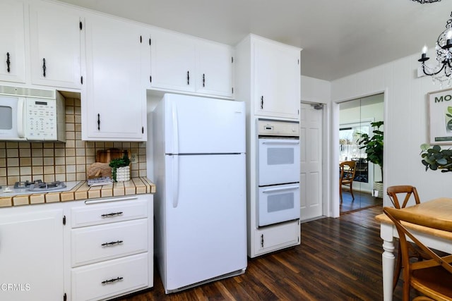 kitchen with dark wood-type flooring, white appliances, tile countertops, and white cabinets