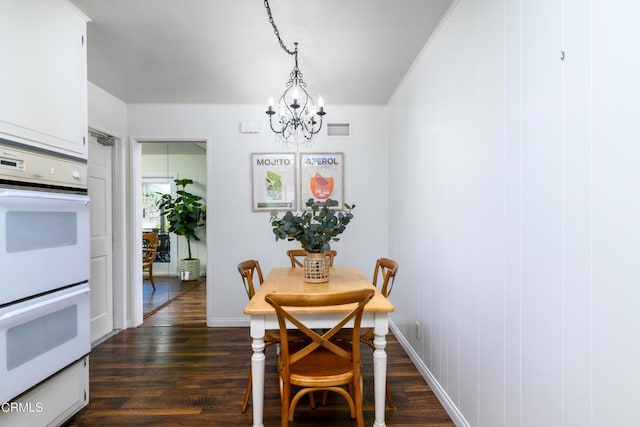 dining area featuring an inviting chandelier and dark hardwood / wood-style floors