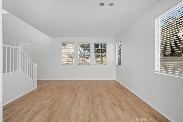 unfurnished room featuring plenty of natural light and light hardwood / wood-style flooring