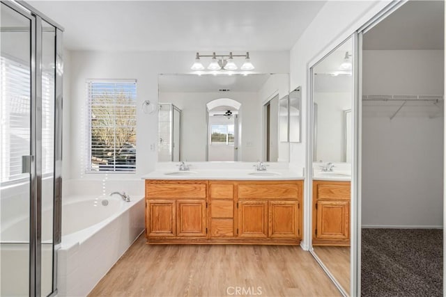 bathroom featuring vanity, hardwood / wood-style flooring, shower with separate bathtub, and ceiling fan