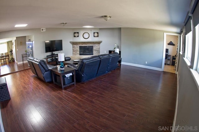 living room featuring dark wood-type flooring and a fireplace