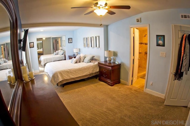 carpeted bedroom with ceiling fan, ensuite bath, vaulted ceiling, and a closet