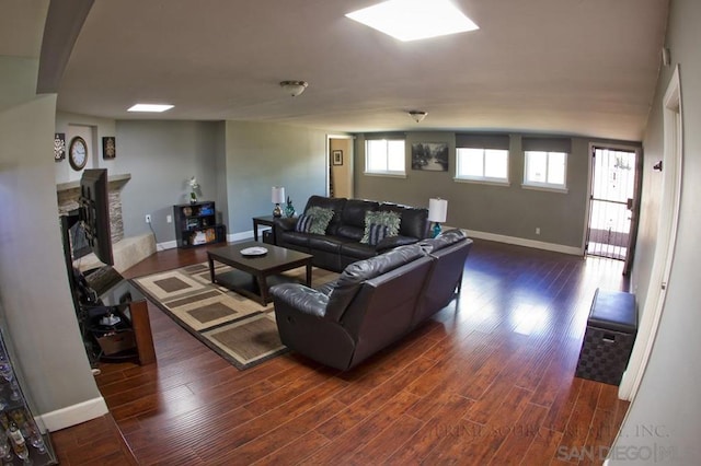 living room with dark hardwood / wood-style flooring and a fireplace