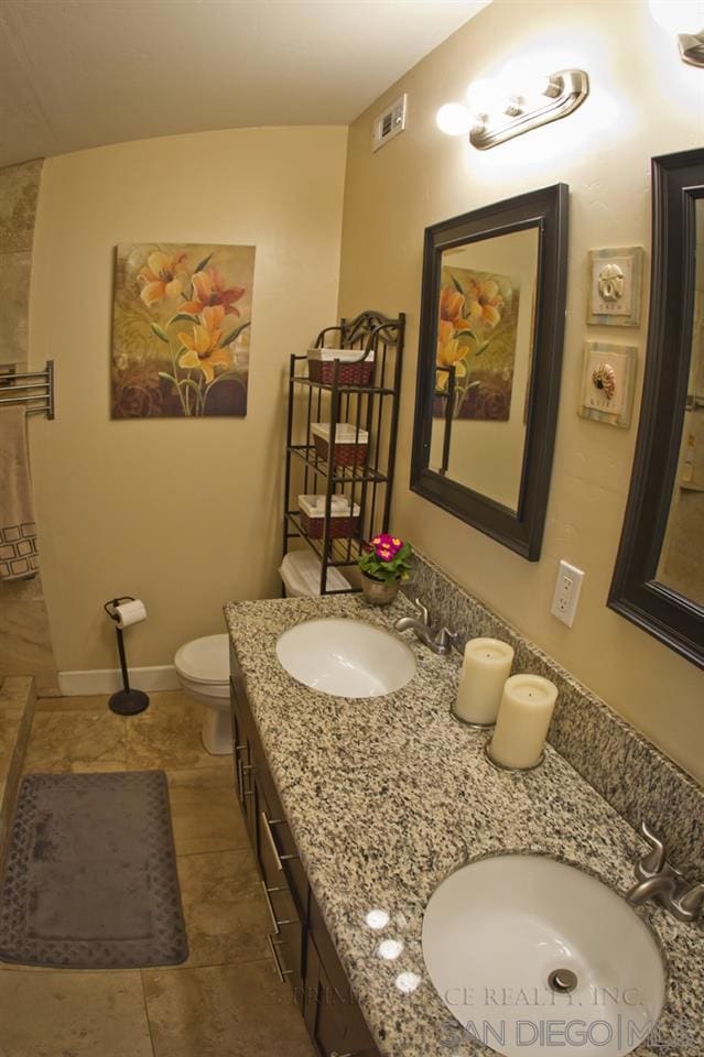 bathroom featuring tile patterned floors, vanity, and toilet