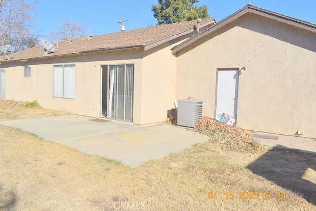 rear view of house featuring a yard, cooling unit, and a patio area