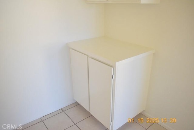 clothes washing area with light tile patterned floors