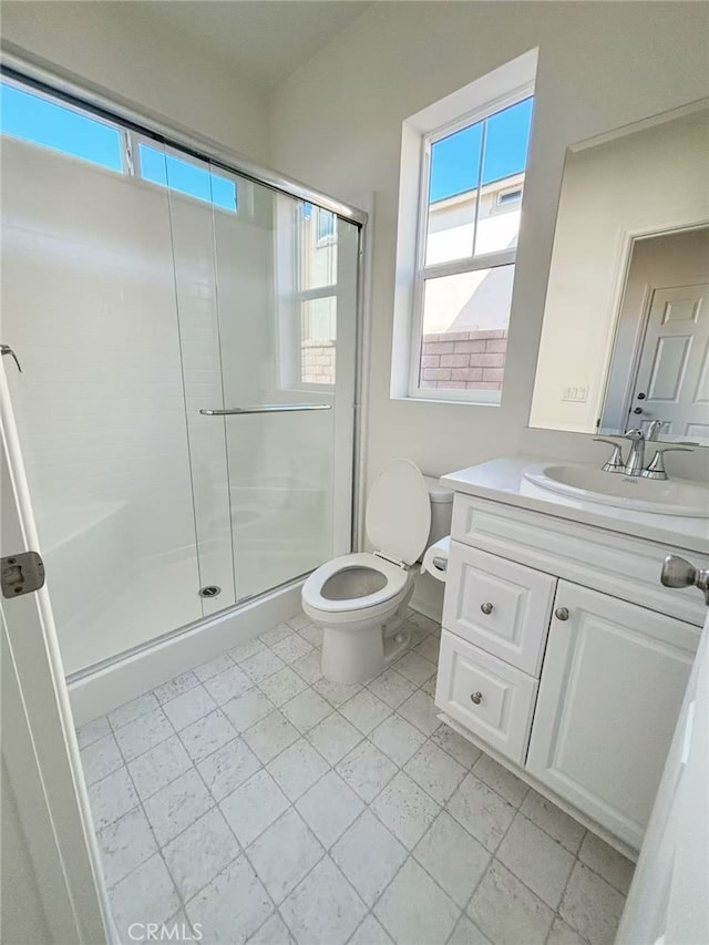 bathroom with vanity, toilet, and a shower with shower door