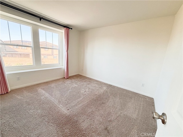 carpeted empty room with baseboards