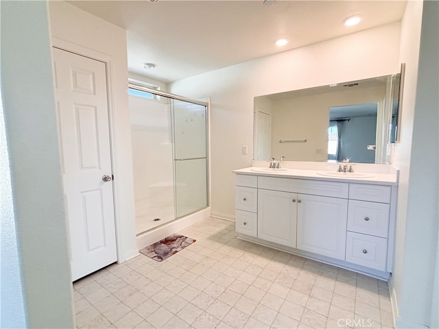 bathroom featuring double vanity, baseboards, a stall shower, and a sink