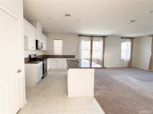 kitchen featuring visible vents, light colored carpet, stainless steel appliances, and a sink